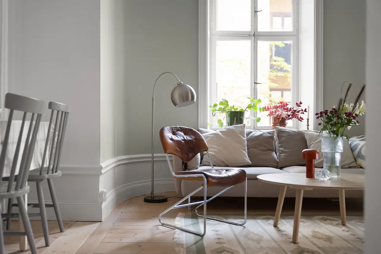 Séjour lumineux de style scandinave : canapé en lin, table basse en bois clair, plantes à la fenêtre